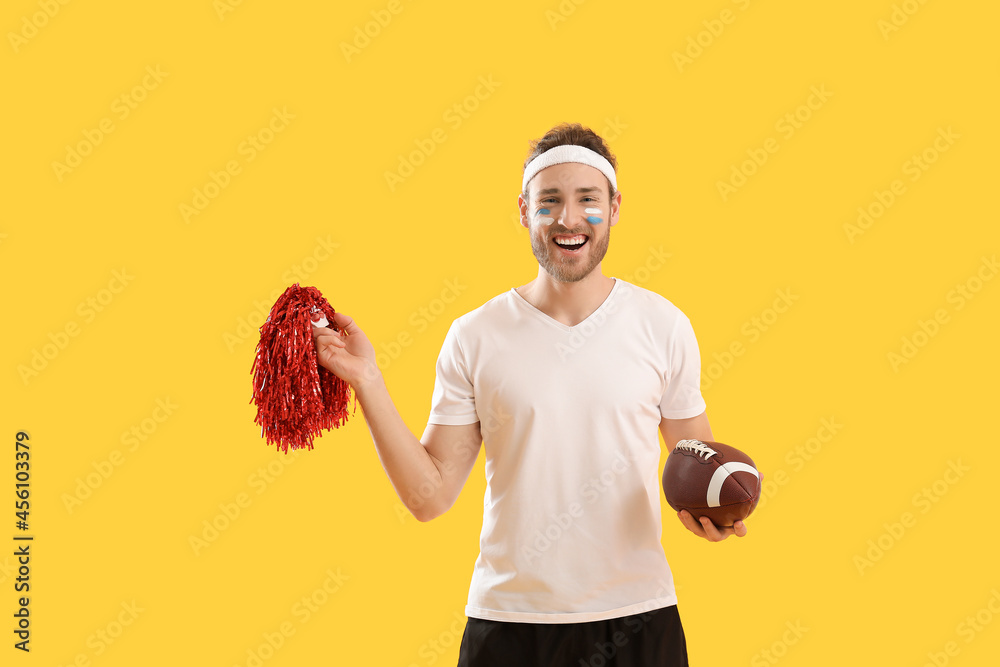 Male cheerleader with rugby ball on color background