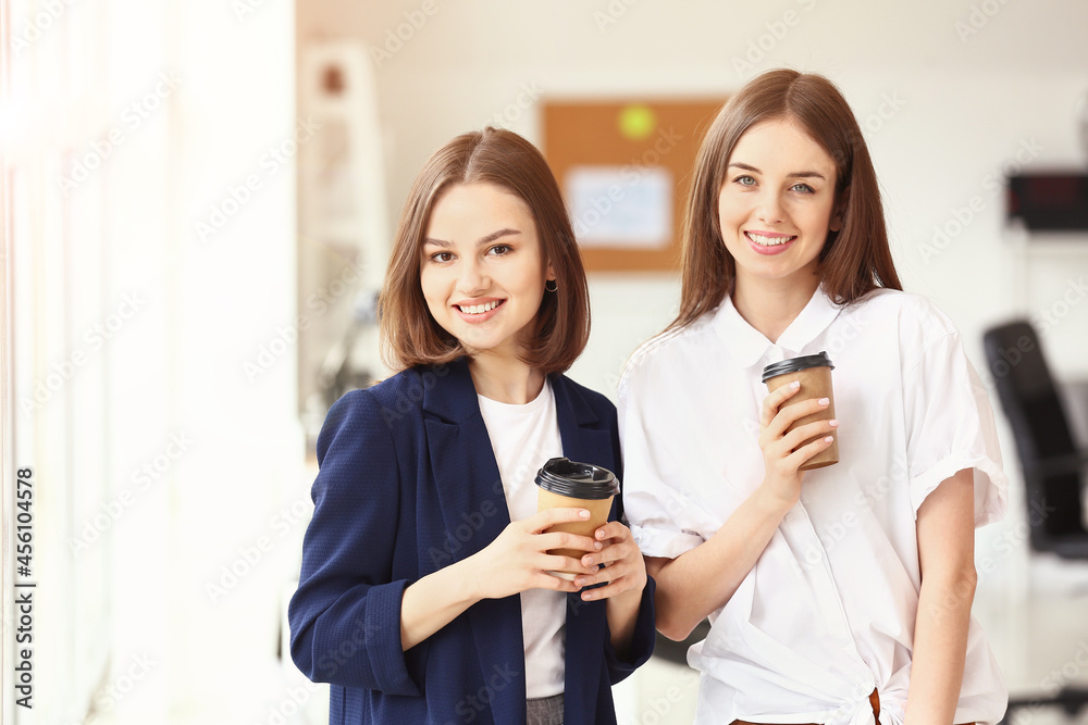 Female colleagues drinking coffee in office