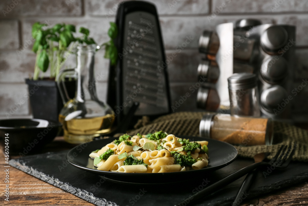 Plate with tasty pasta and pesto sauce on table