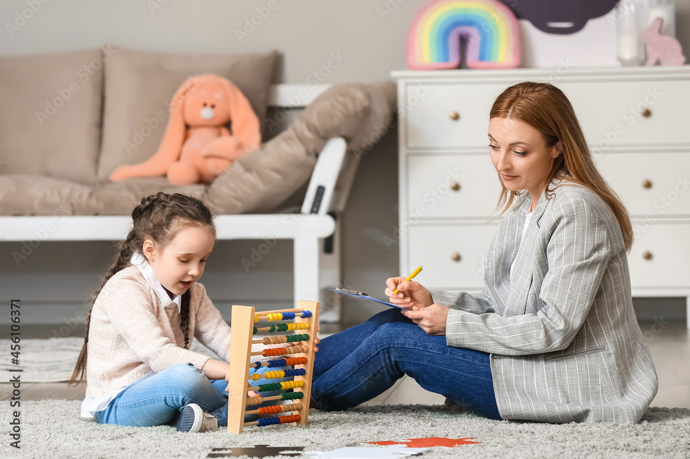 Female psychologist working with girl suffering from autistic disorder in office