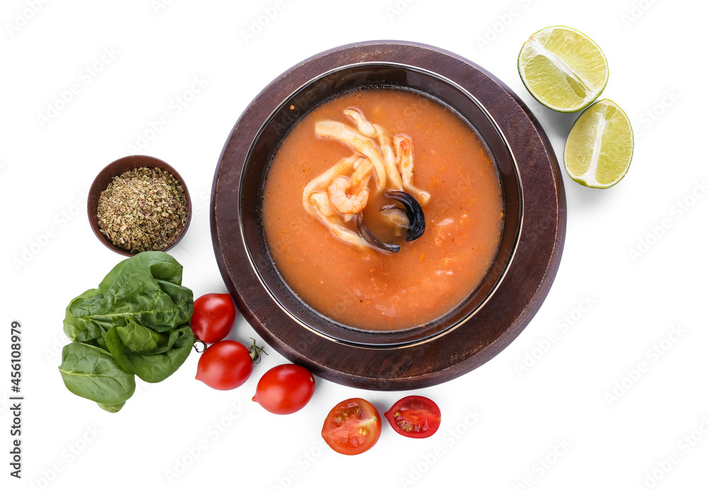 Bowl of tasty Cacciucco soup and ingredients on white background