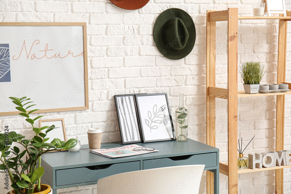 Stylish workplace near white brick wall