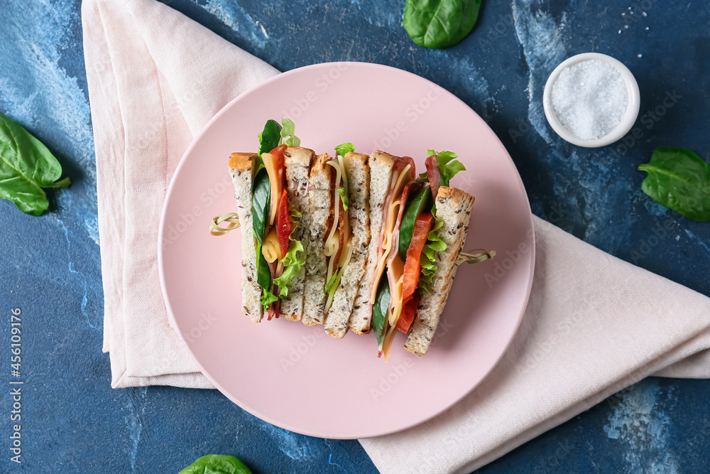 Plate with tasty sandwiches on color background