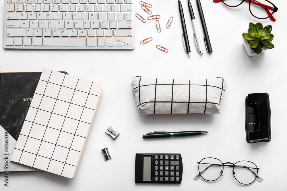 Composition with stationery, keyboard and pencil case on white background, closeup