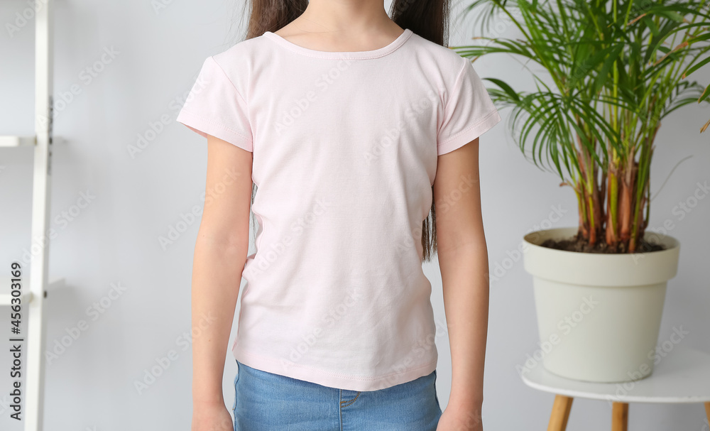 Little girl in stylish t-shirt at home, front view