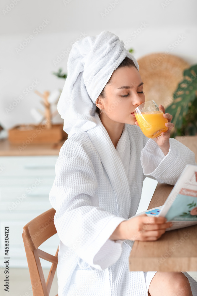 Young woman drinking juice at home