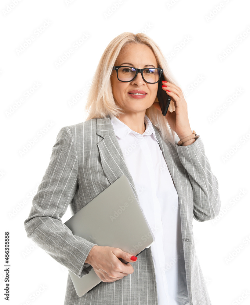 Mature businesswoman with laptop talking by phone on white background