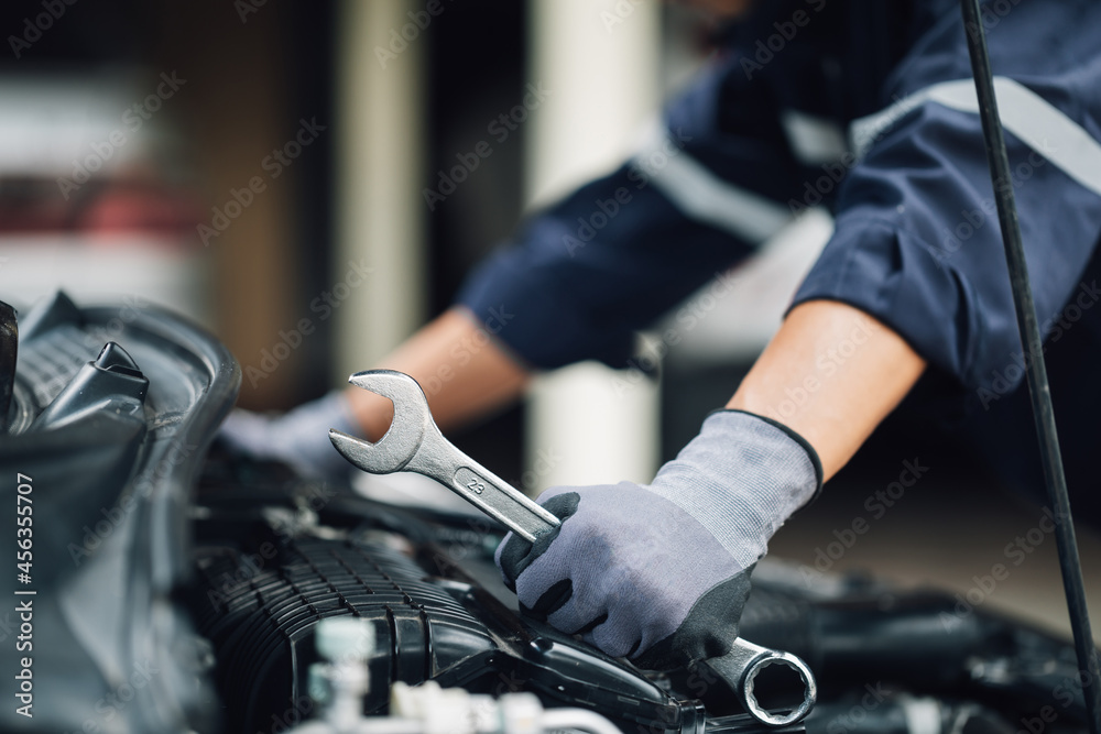 Mechanic works on the engine of the car in the garage. Repair service. Concept of car inspection ser