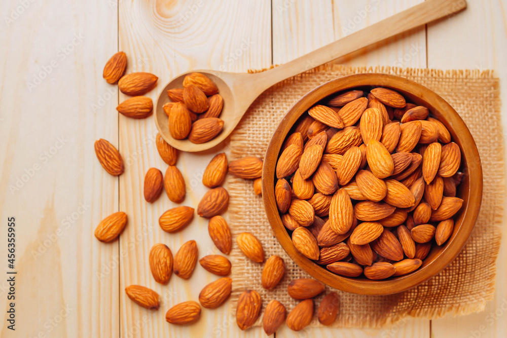 Almond top view on wooden table with wooden spoon or scoop Almonds in a wooden bowl The nuts are fre