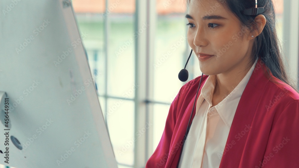 Businesswoman wearing headset working actively in office . Call center, telemarketing, customer supp