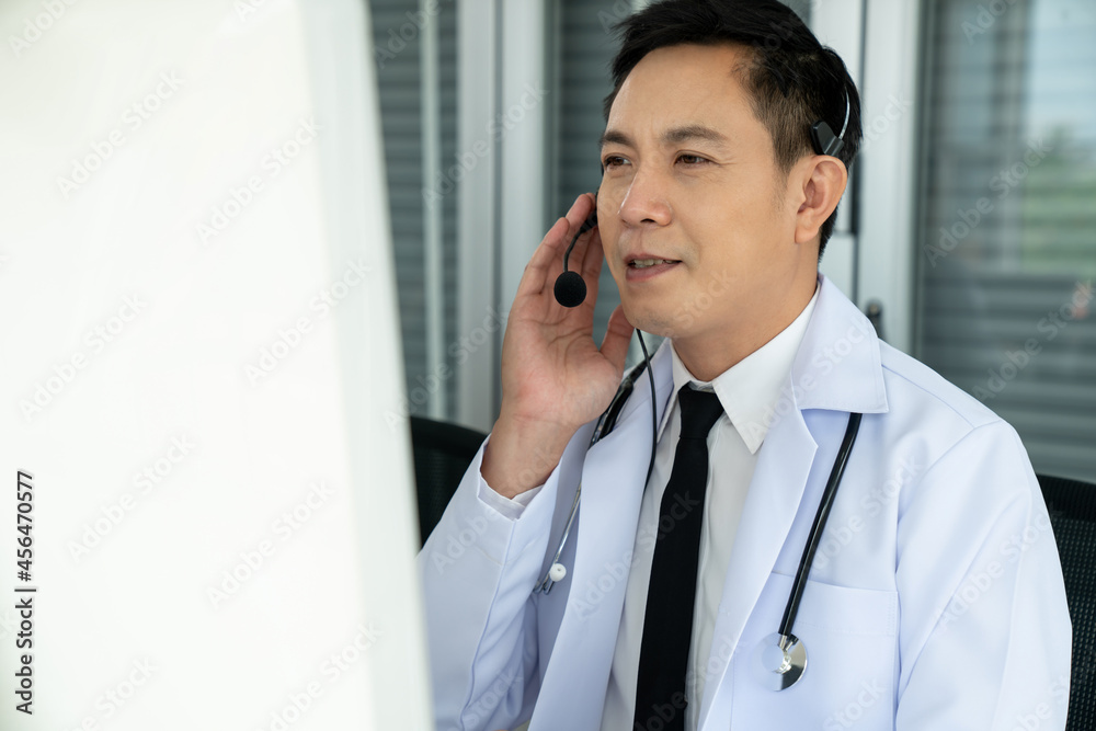 Doctor wearing headset talking actively on video call in a clinic or hospital . Concept of telehealt