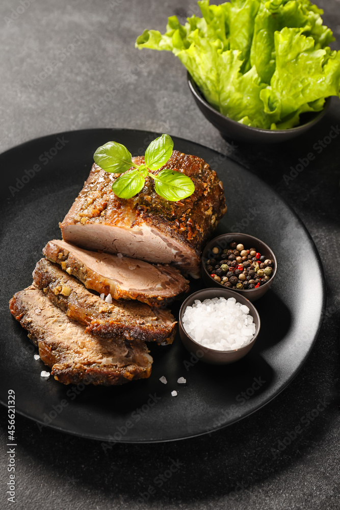 深色背景下有美味的牛脯肉、香料和生菜的盘子