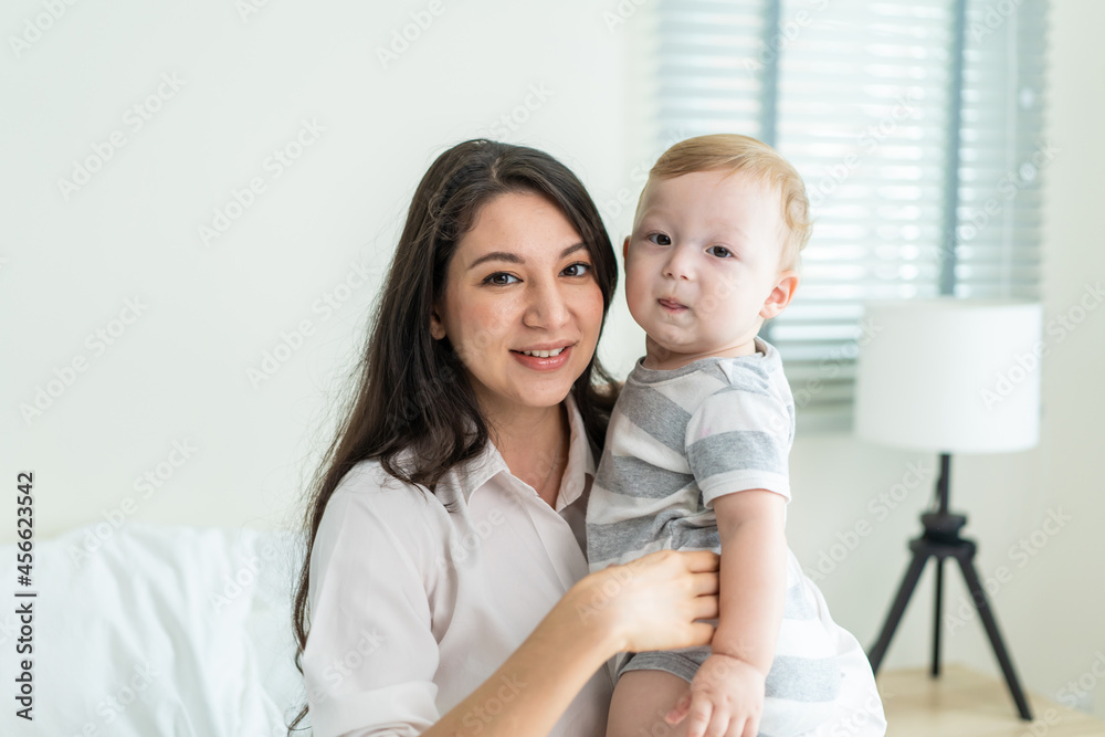 Portrait of Caucasian happy family smiling, look at camera in bedroom. 