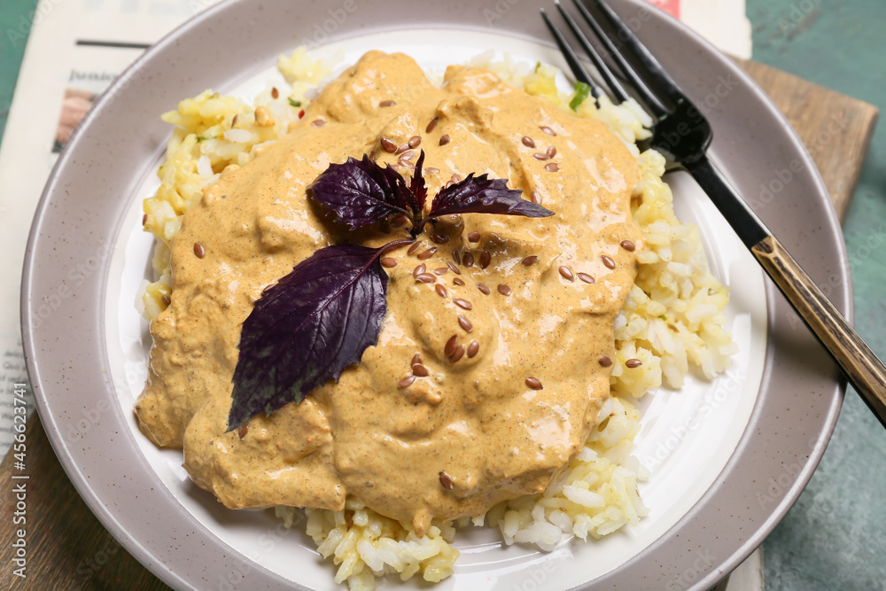 Plate of tasty chicken curry with rice on table, closeup