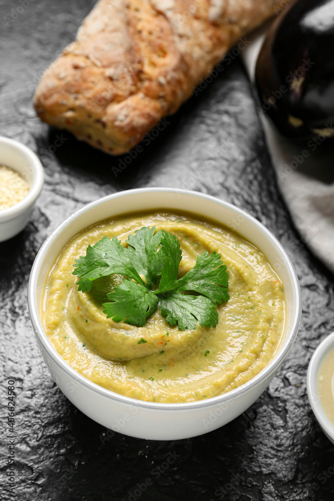 Bowl with tasty baba ghanoush on dark background, closeup