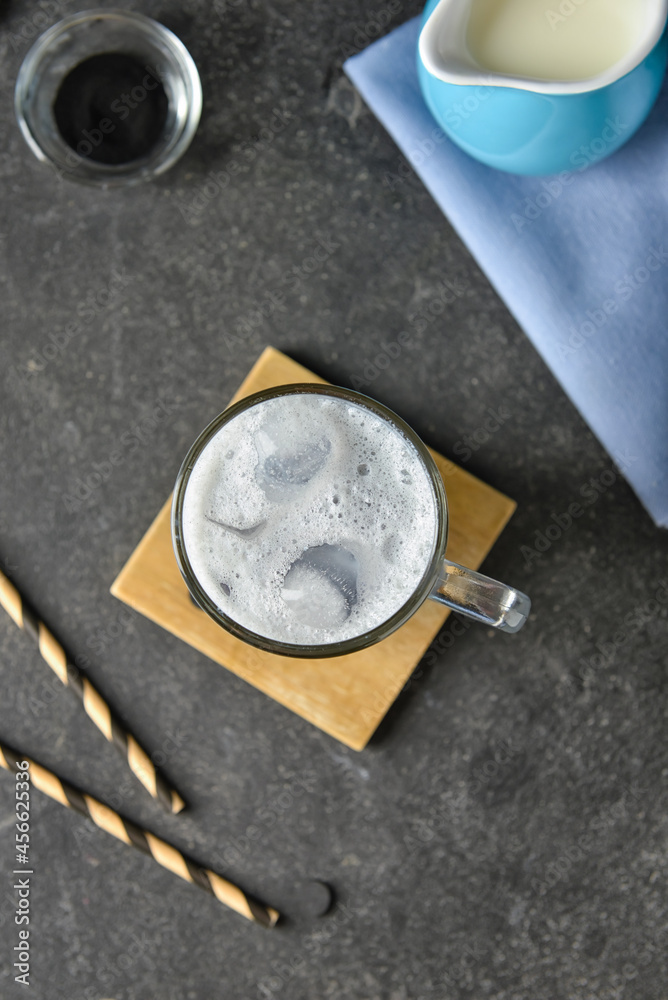 Glass cup of tasty Charcoal Latte on dark background