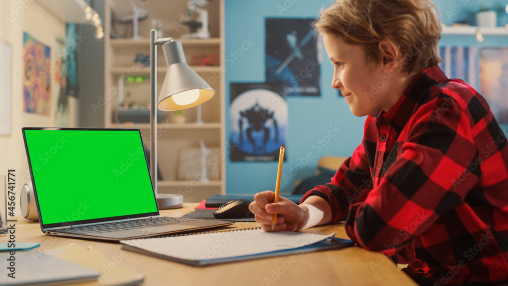 Smart Young Boy Attending Online Class on Laptop Computer with Green Screen at Home. Happy Teenager 