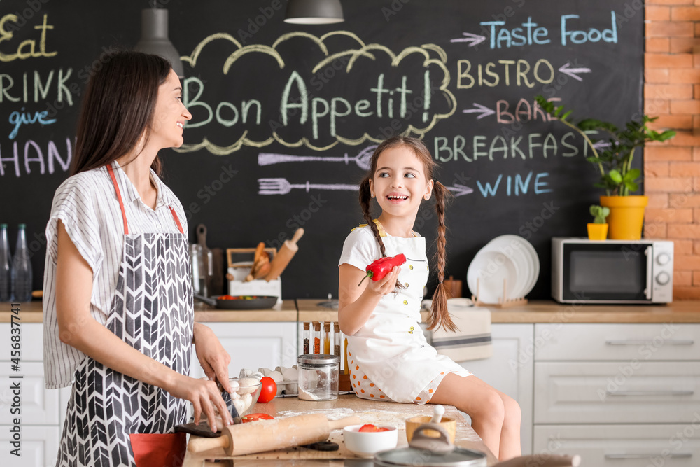 Young mother and daughter in kitchen at home