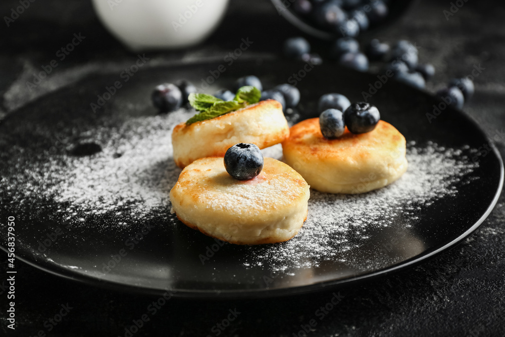 Plate with tasty cottage cheese pancakes and blueberry on table