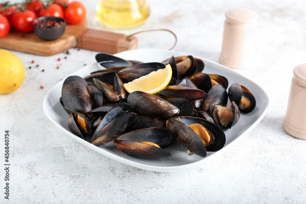 Tasty mussels with lemon on light background