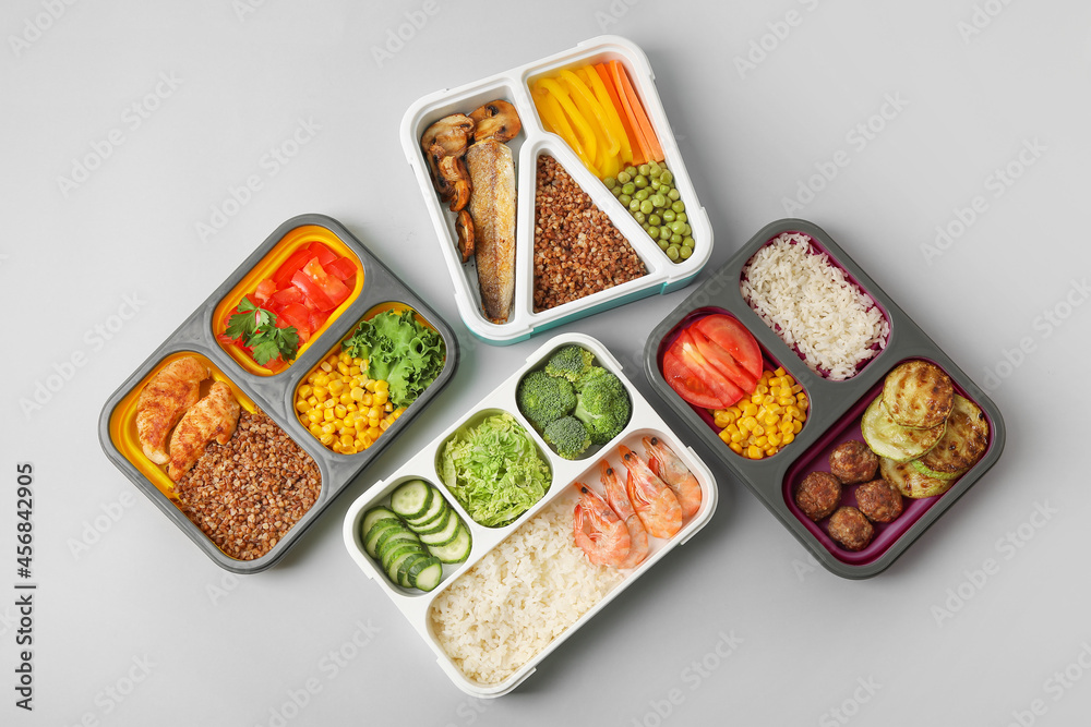 Different containers with healthy food on light background