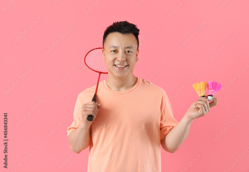 Sporty male badminton player on color background