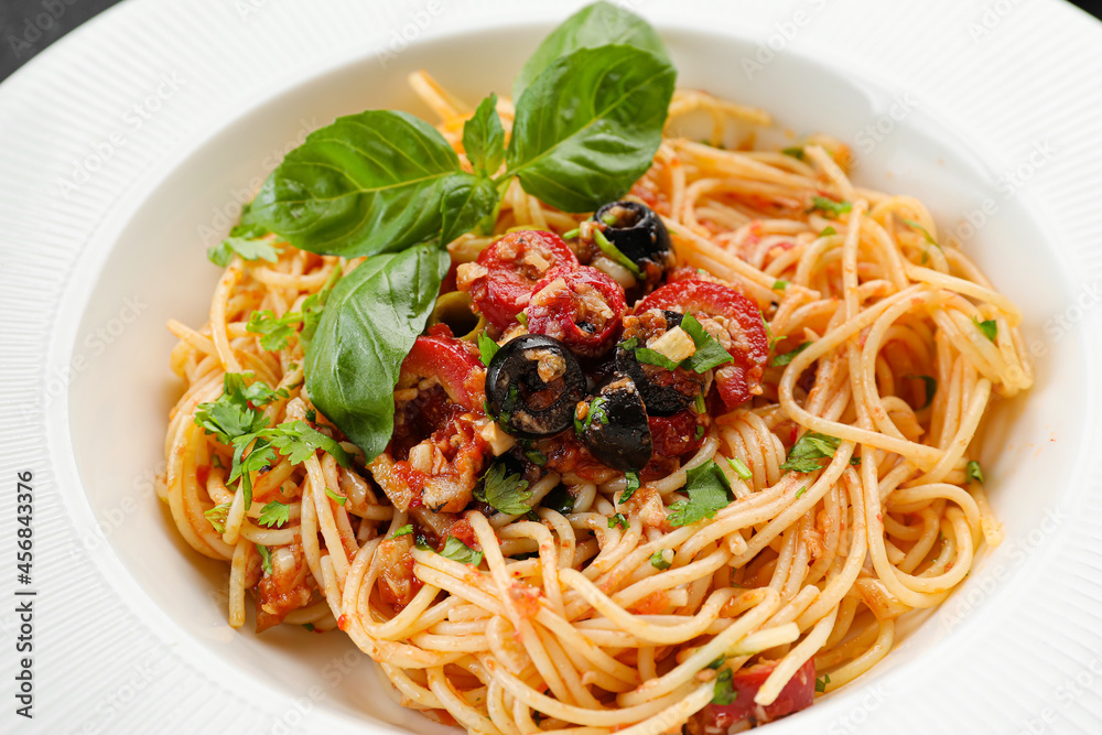 Tasty Pasta Puttanesca on plate, closeup