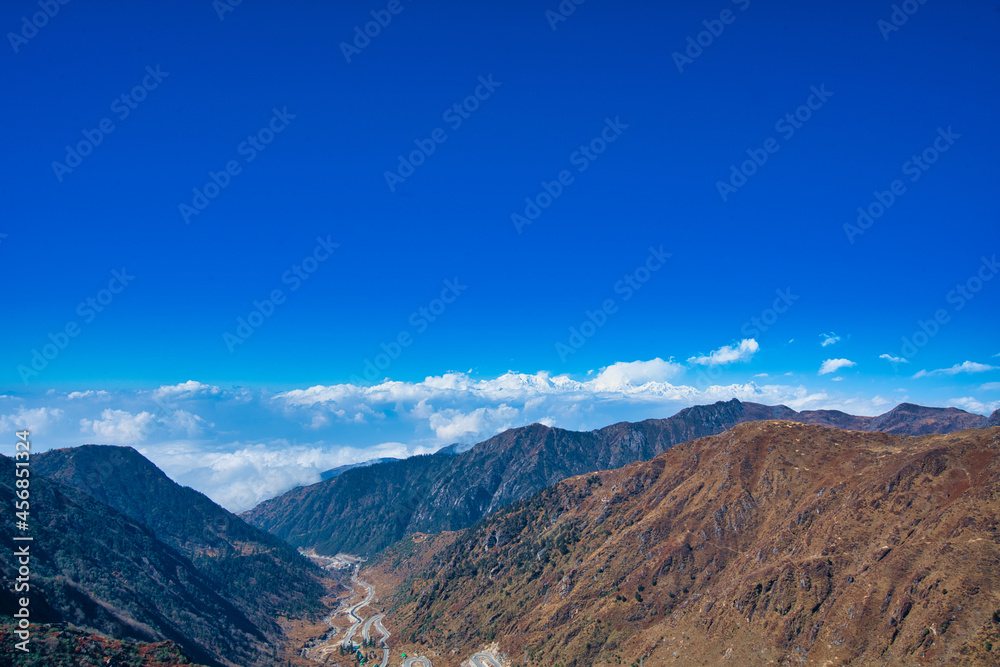 蓝天白云下的茶色山脉的自然风光。山景