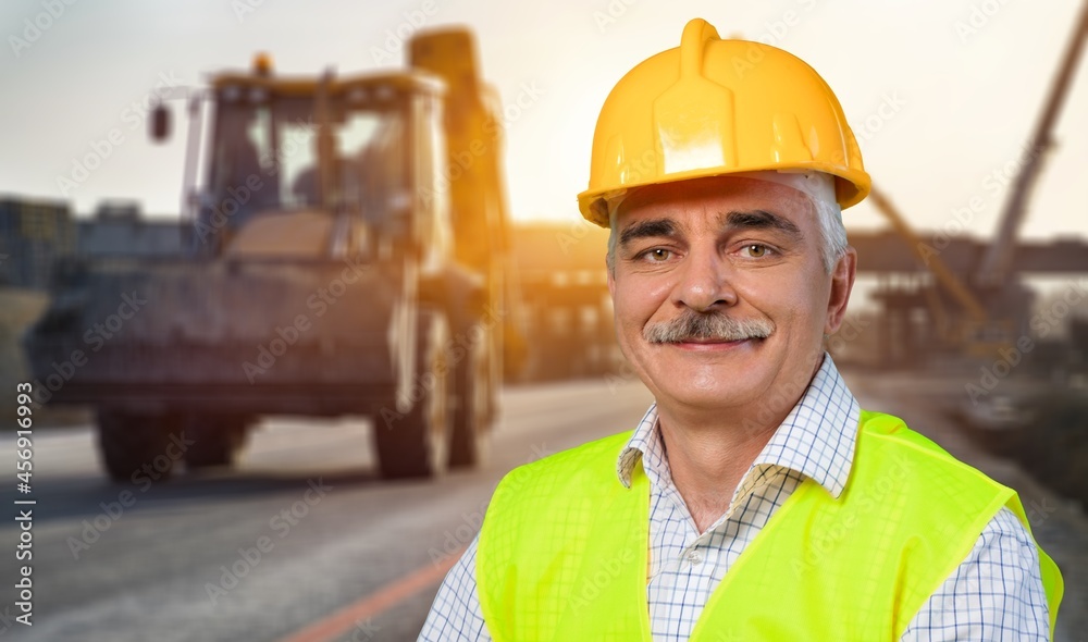 A young foreman looking into camera wearing a hard hat after a long day of work on site