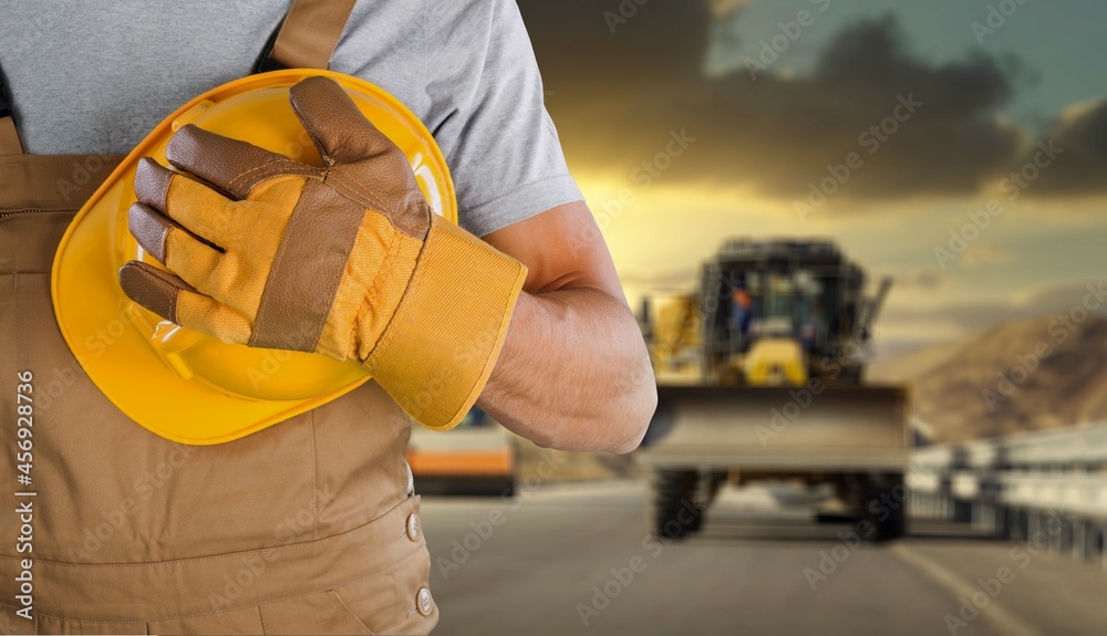 A young foreman looking into camera wearing a hard hat after a long day of work on site