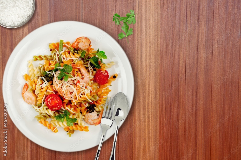 Spaghetti with meat in tomato sauce in a bowl on a desk