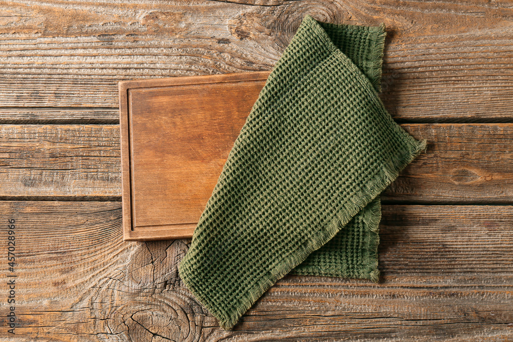 Stylish napkin and board on wooden background