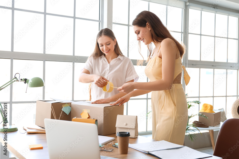 Female business owner and seller packing order in warehouse store