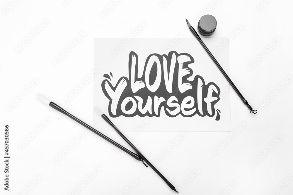 纸上有文字LOVE YOURSELF和白底画笔