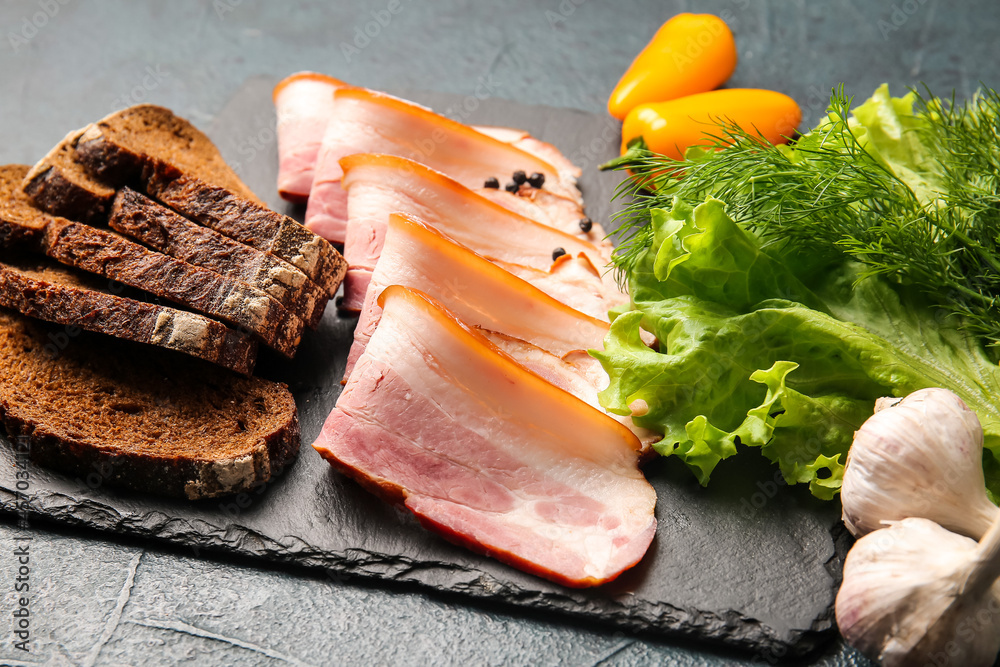 Composition with slices of tasty smoked bacon on dark background