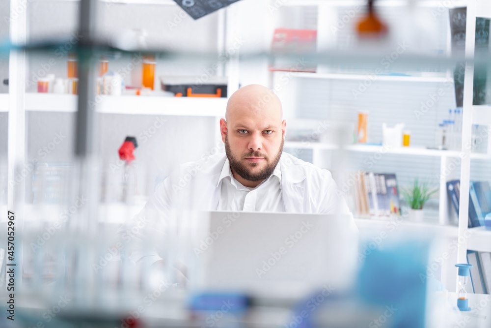 Male Scientist Working on a Computer with Display Showing Gene Editing Interface. Microbiologist is 