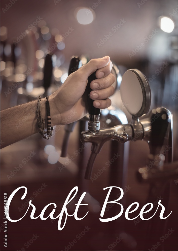 Craft beer text over hand holding beer tap at the bar