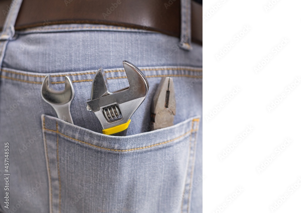 Close up view of multiple tools in the jeans pocket of repairman