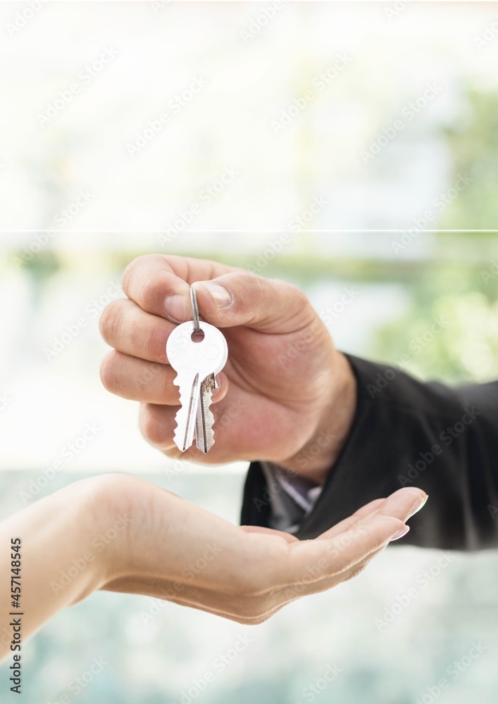 Close up of real estate agent giving keys house to customer