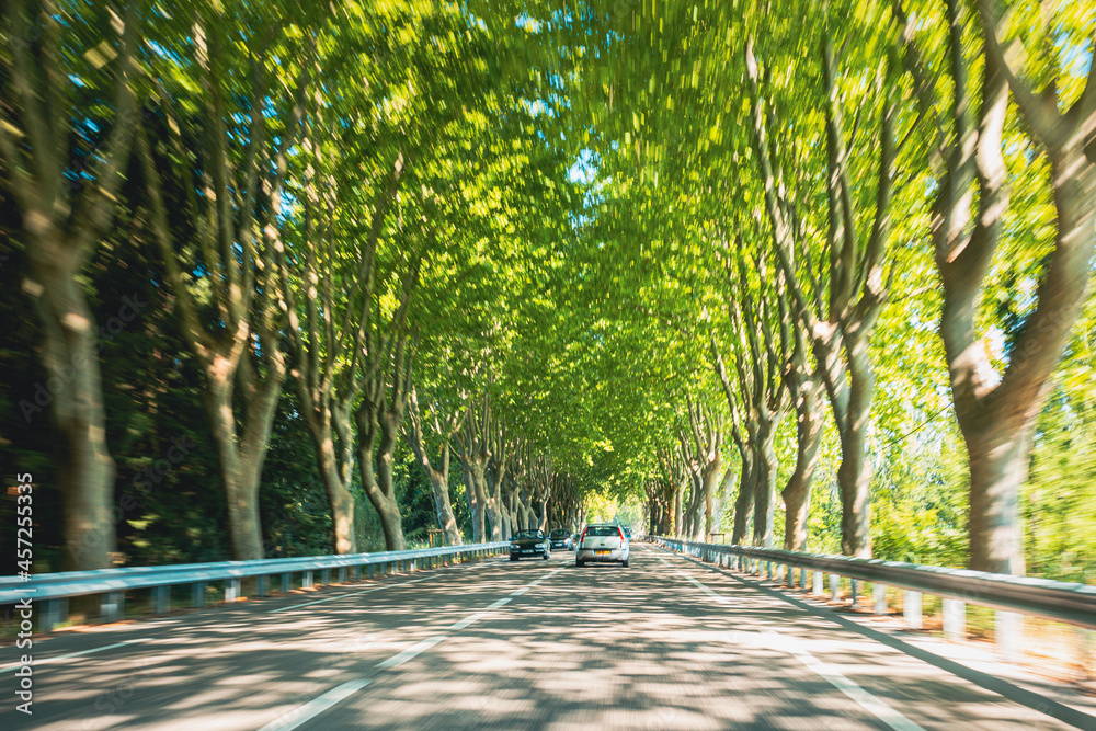 高速路上超速行驶的汽车，乡村沥青路。运动模糊背景