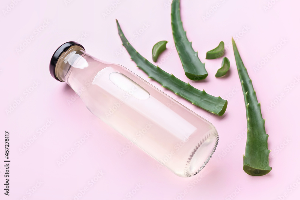 Bottle of healthy aloe juice on color background