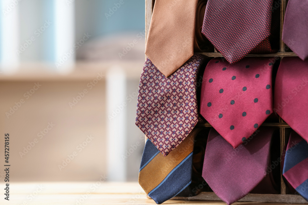 Box with stylish neckties on table