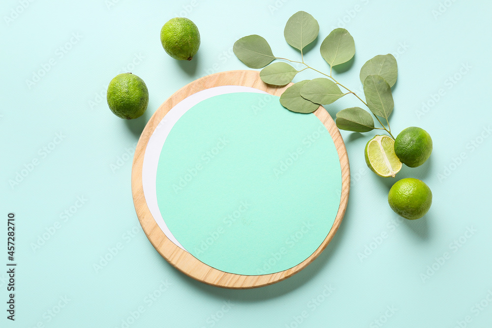 Composition with blank card, limes and plant branch on color background