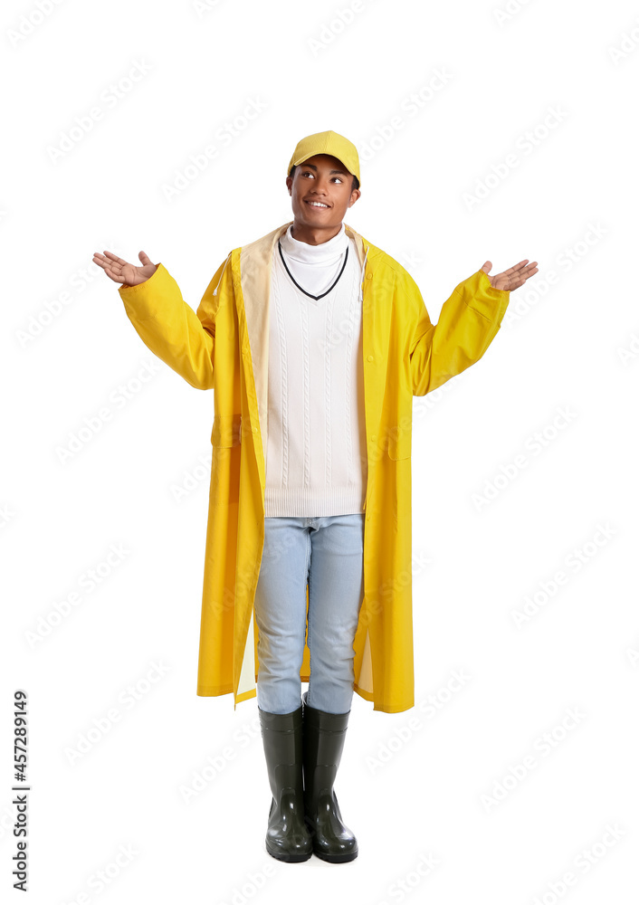 Handsome stylish African-American guy in raincoat on white background