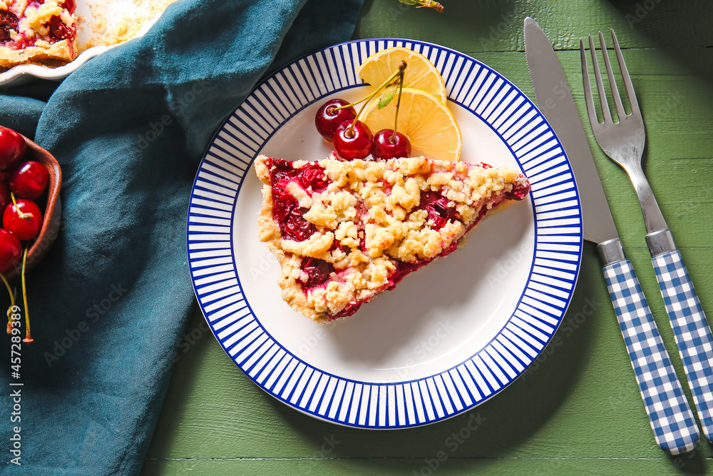 Plate with piece of tasty cherry pie and lemon on color wooden background, closeup