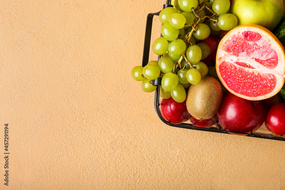 Basket with fresh fruits on color background