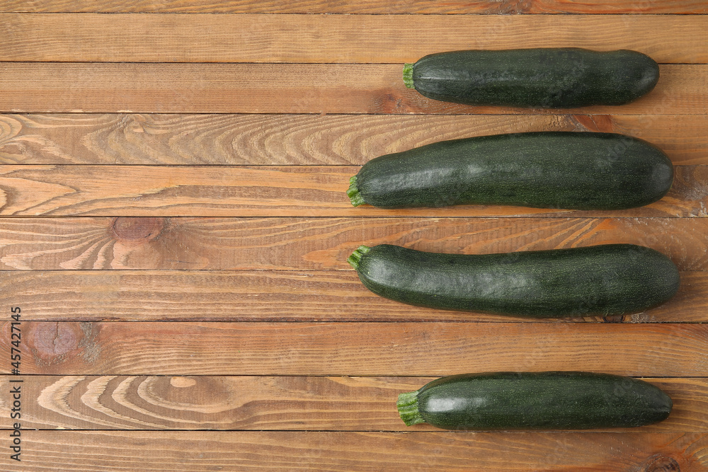 Fresh zucchini squashes on wooden background