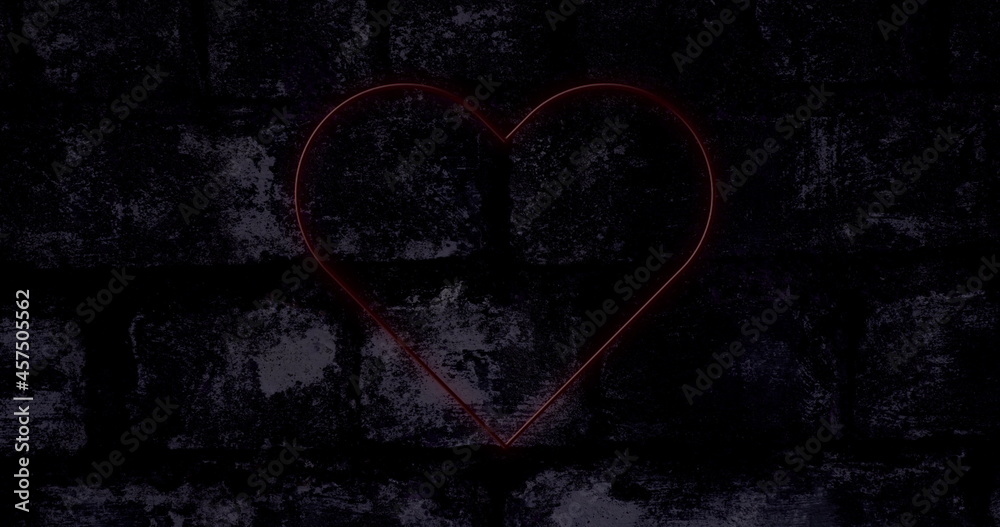 Image of red neon heart flashing on dark brick wall