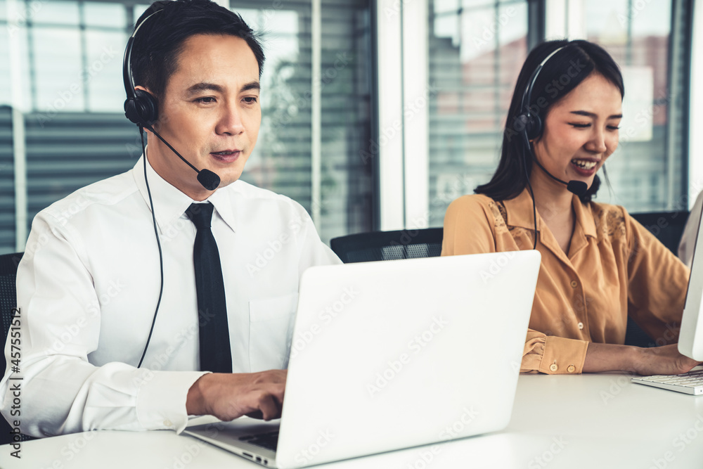 Business people wearing headset working actively in office . Call center, telemarketing, customer su