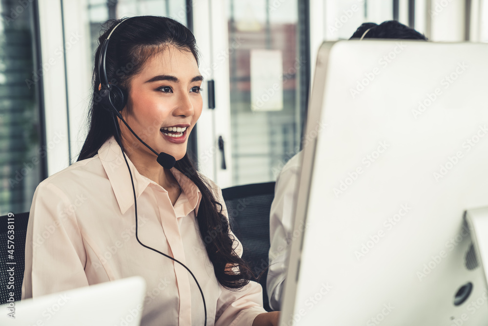 Businesswoman wearing headset working actively in office . Call center, telemarketing, customer supp